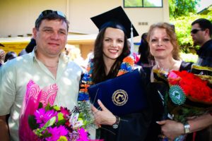 Adriana with her parents at graduation